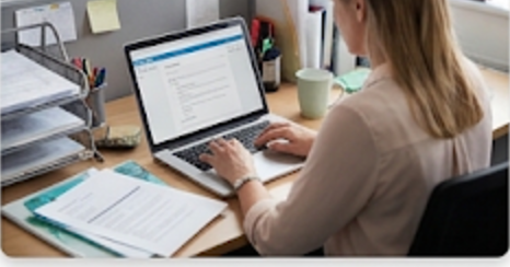 A coordinator at her desk working on a laptop